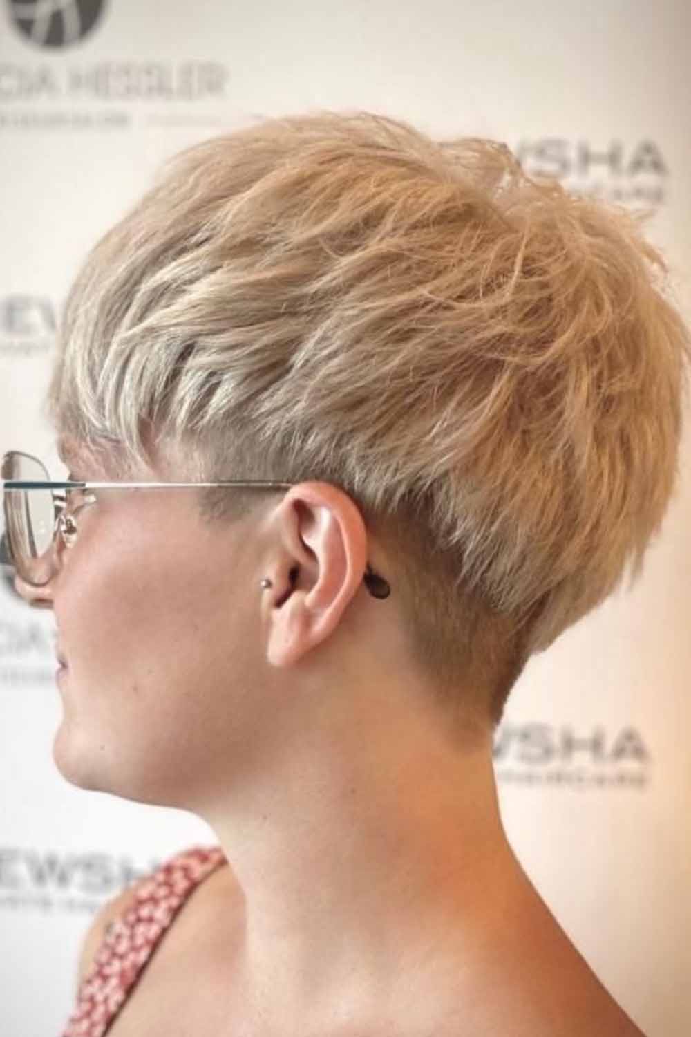 A confident model showcasing a layered, short bowl cut hairstyle that highlights unique features and provides an edgy look.
