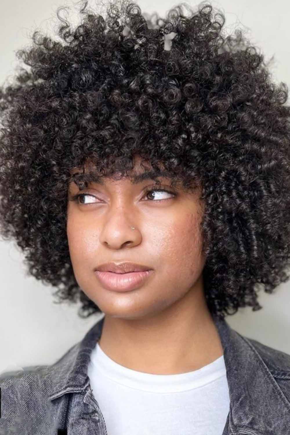 Woman with a warm toned, mid-length winter haircut styled with gentle waves